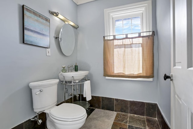 1041 Franklin Ave, Columbus, OH 43205 - bathroom featuring stone tile floors, toilet, a sink, and baseboards