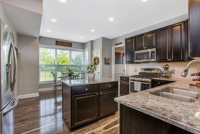 5119 Butterworth Green Dr, New Albany, OH 43054 - kitchen featuring appliances with stainless steel finishes, a sink, light stone countertops, baseboards, and a kitchen island