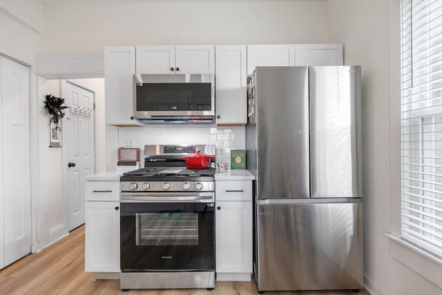 357 E Welch Ave, Columbus, OH 43207 - kitchen with appliances with stainless steel finishes, light countertops, white cabinetry, and tasteful backsplash