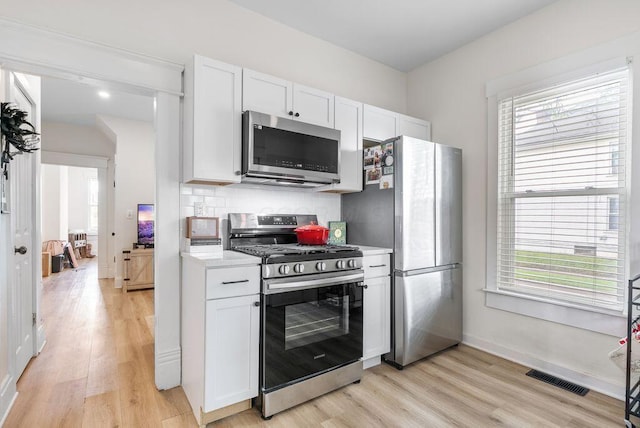 357 E Welch Ave, Columbus, OH 43207 - kitchen featuring stainless steel appliances, light countertops, light wood-type flooring, and white cabinetry