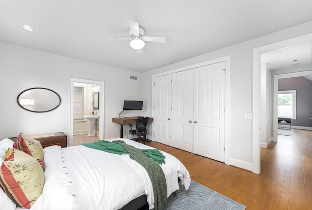 308 Jackson St, Columbus, OH 43206 - bedroom with light wood-style flooring, a closet, baseboards, a ceiling fan, and ensuite bath