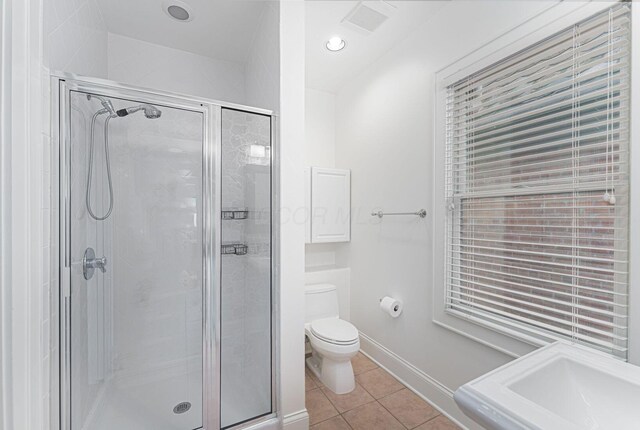 308 Jackson St, Columbus, OH 43206 - bathroom featuring tile patterned floors, a shower stall, toilet, a sink, and baseboards