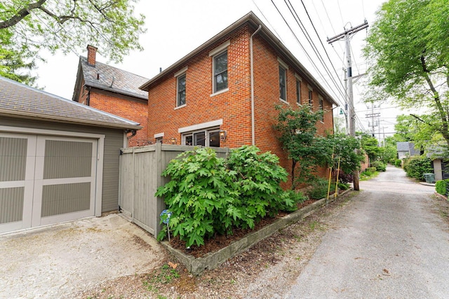 308 Jackson St, Columbus, OH 43206 - view of side of property featuring fence, brick siding, and a garage
