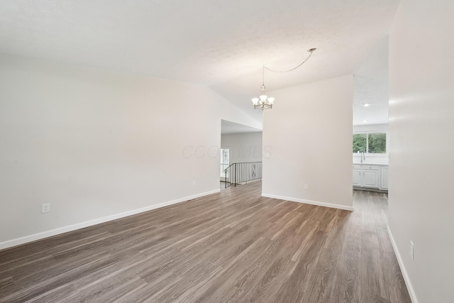 3368 Pine Valley Rd, Columbus, OH 43219 - unfurnished room with wood finished floors, a chandelier, baseboards, and lofted ceiling