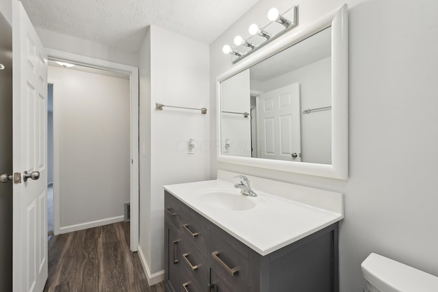 3368 Pine Valley Rd, Columbus, OH 43219 - bathroom featuring wood finished floors, vanity, toilet, and baseboards
