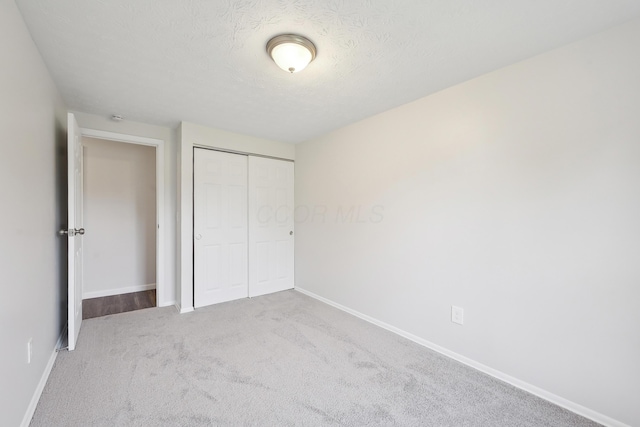 3368 Pine Valley Rd, Columbus, OH 43219 - unfurnished bedroom featuring baseboards, a closet, carpet, and a textured ceiling