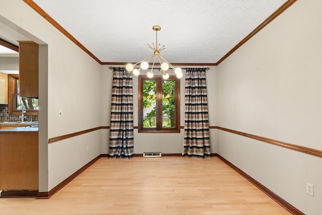 750 Pepper Ct, Westerville, OH 43082 - unfurnished dining area with a chandelier, light wood-style flooring, crown molding, and a textured ceiling