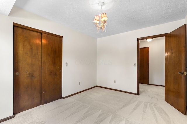 750 Pepper Ct, Westerville, OH 43082 - unfurnished bedroom featuring light carpet, a chandelier, a textured ceiling, and a closet