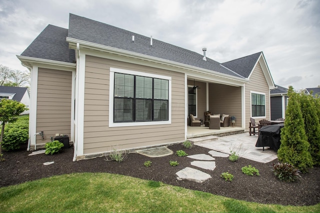 rear view of house with a patio, an outdoor hangout area, and a shingled roof