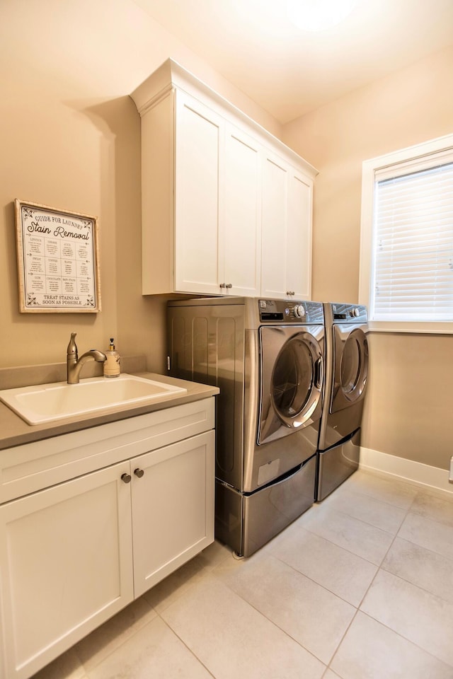 laundry room featuring independent washer and dryer, cabinet space, light tile patterned flooring, and baseboards