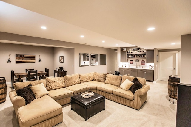 living room with recessed lighting, wet bar, and light carpet