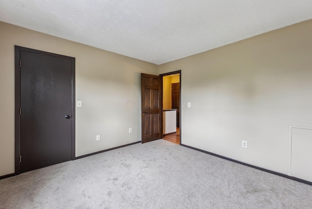 unfurnished bedroom with carpet floors and baseboards