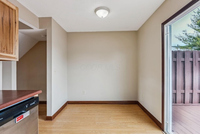 unfurnished dining area with light wood-style flooring and baseboards