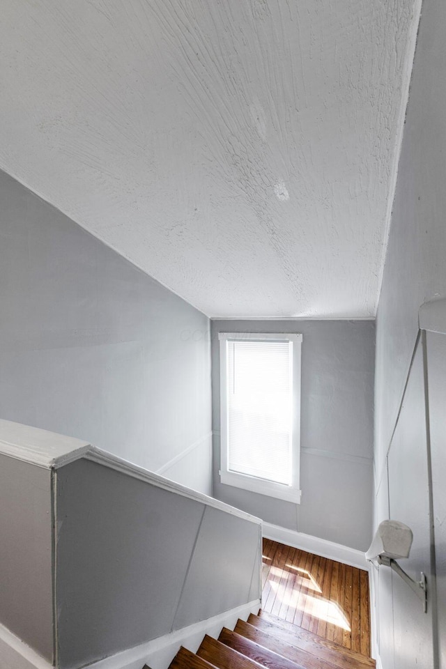 1165 Wager St Unit 1165-1167, Columbus, OH 43206 - staircase featuring hardwood / wood-style flooring, baseboards, a textured ceiling, and lofted ceiling