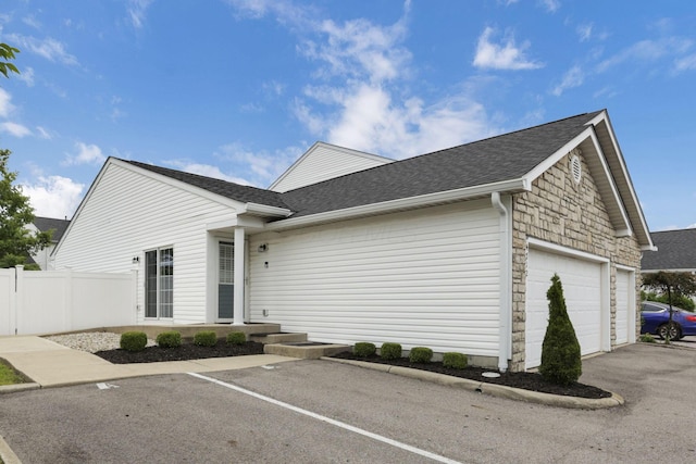 4712 Shalers Dr Unit 54A, Columbus, OH 43228 - view of front of home with a shingled roof, fence, a garage, and uncovered parking
