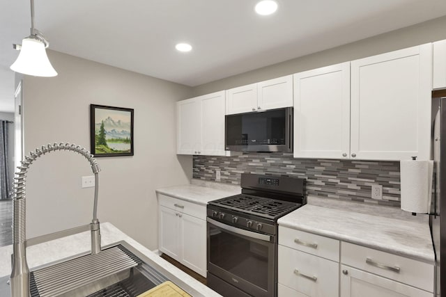 4712 Shalers Dr Unit 54A, Columbus, OH 43228 - kitchen featuring stainless steel microwave, gas stove, light countertops, white cabinetry, and recessed lighting