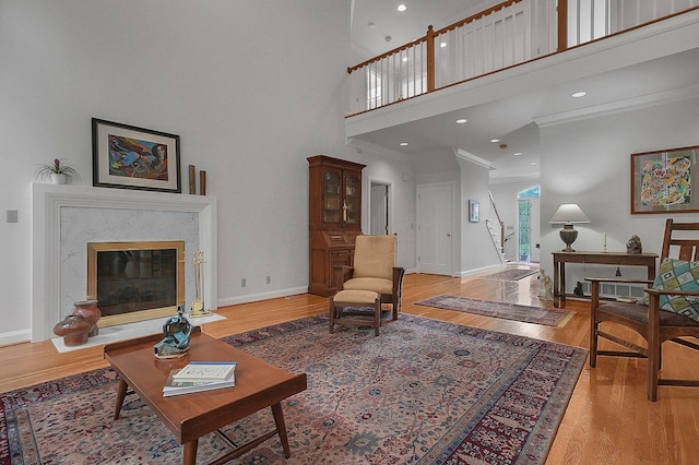 8259 Spruce Needle Ct, Columbus, OH 43235 - living room with light wood-type flooring, baseboards, a towering ceiling, and a premium fireplace