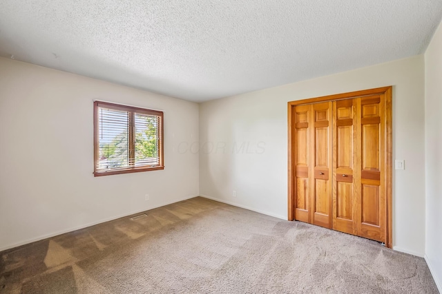 12502 Barbara Dr, Kenton, OH 43326 - unfurnished bedroom featuring carpet, a textured ceiling, baseboards, and a closet