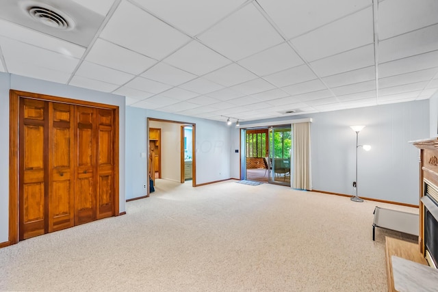12502 Barbara Dr, Kenton, OH 43326 - unfurnished living room featuring baseboards, a fireplace with flush hearth, a drop ceiling, and carpet floors