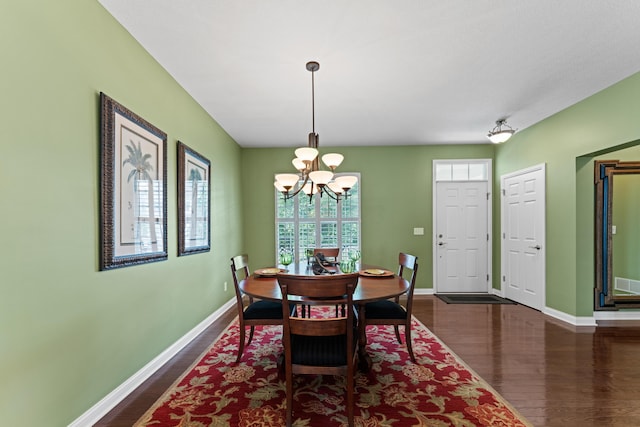 dining space featuring a chandelier, dark wood-style floors, and baseboards