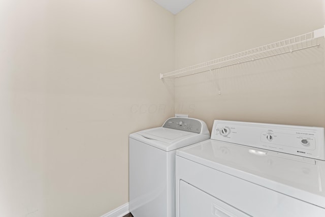 laundry area with separate washer and dryer and baseboards