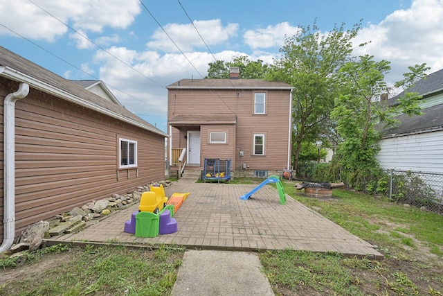 back of property featuring a patio area, fence, a fire pit, and a chimney