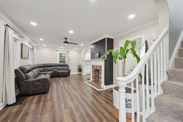 living area with dark wood finished floors, ornamental molding, stairway, recessed lighting, and a ceiling fan
