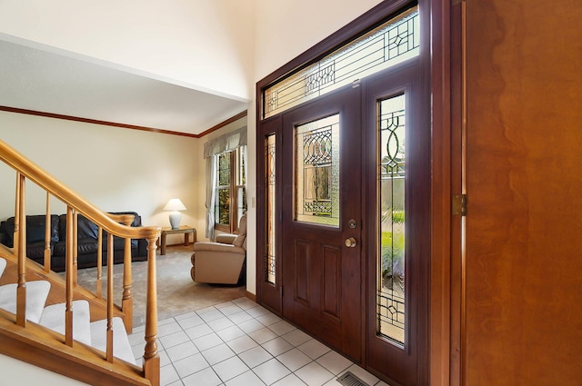 entrance foyer featuring light colored carpet, stairway, light tile patterned floors, a towering ceiling, and baseboards