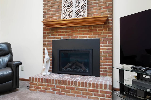 detailed view of a fireplace, carpet, and baseboards