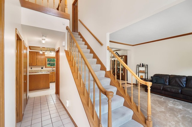 stairway featuring tile patterned floors and crown molding