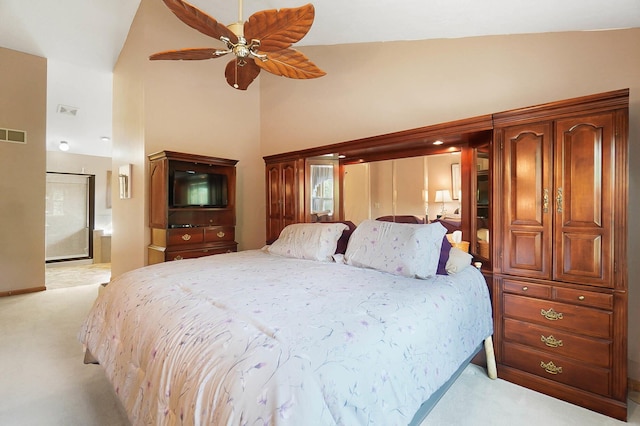 bedroom with light colored carpet, high vaulted ceiling, connected bathroom, and a ceiling fan