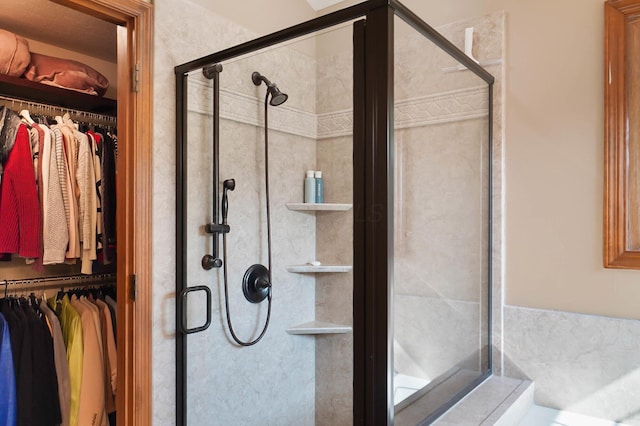 bathroom with a stall shower and a walk in closet