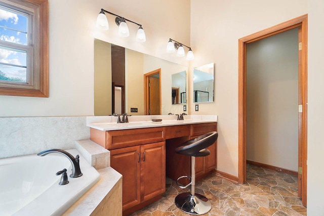 bathroom with a bath, double vanity, baseboards, and stone finish flooring