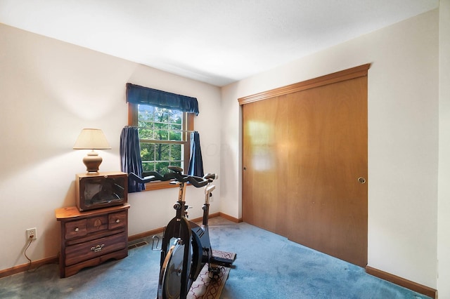 workout area featuring carpet and baseboards