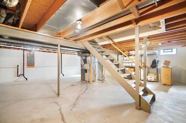 basement featuring electric panel, stairs, and heating unit