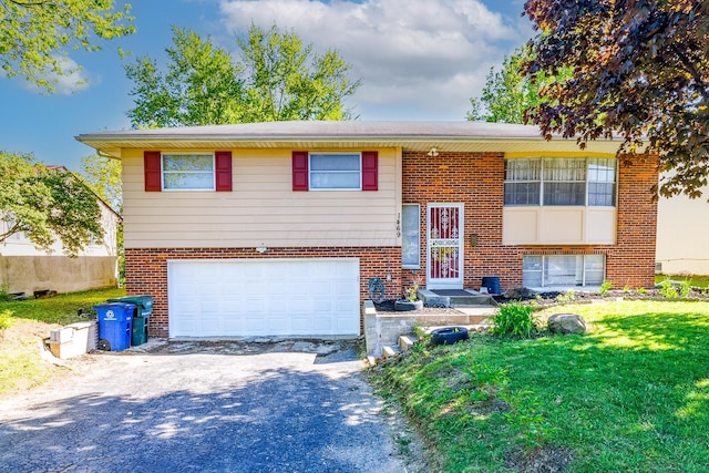 1469 Sandalwood Pl, Columbus, OH 43229 - bi-level home with a garage, brick siding, driveway, and a front lawn
