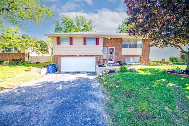 1469 Sandalwood Pl, Columbus, OH 43229 - split foyer home with driveway, brick siding, a garage, and a front yard