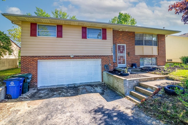 1469 Sandalwood Pl, Columbus, OH 43229 - raised ranch featuring an attached garage, brick siding, and driveway