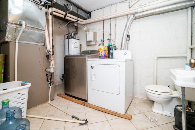 1469 Sandalwood Pl, Columbus, OH 43229 - bathroom with independent washer and dryer, water heater, concrete block wall, tile patterned flooring, and toilet