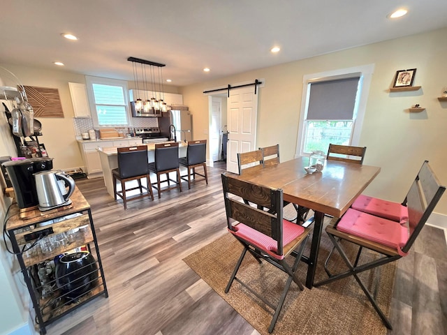 690 E Kossuth St, Columbus, OH 43206 - dining room featuring a barn door, recessed lighting, and dark wood-type flooring