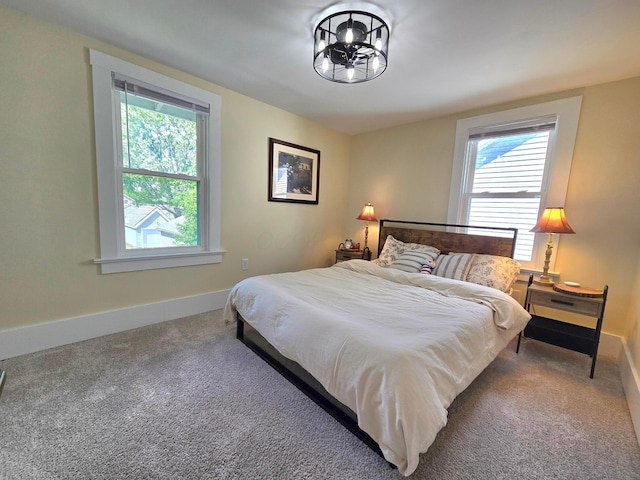 690 E Kossuth St, Columbus, OH 43206 - bedroom featuring multiple windows, carpet floors, baseboards, and a chandelier
