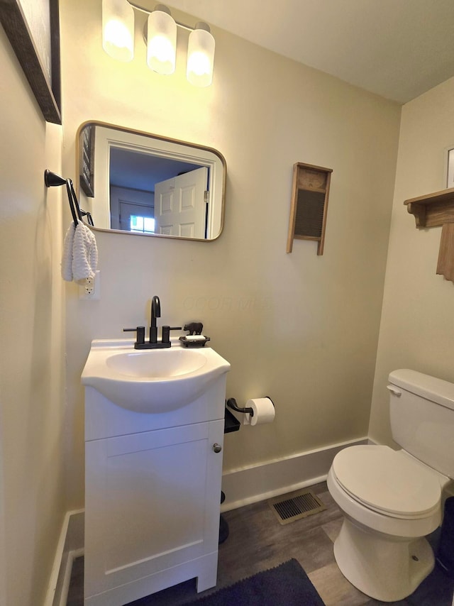 690 E Kossuth St, Columbus, OH 43206 - half bath with toilet, baseboards, wood finished floors, and vanity