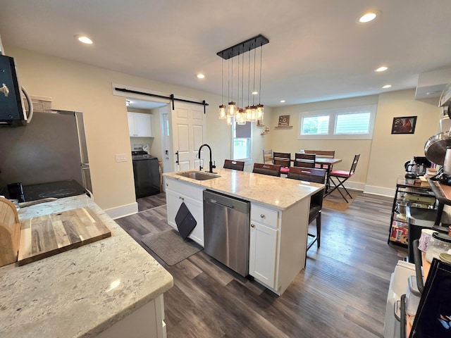 690 E Kossuth St, Columbus, OH 43206 - kitchen with stainless steel appliances, a sink, a barn door, washer / dryer, and white cabinets