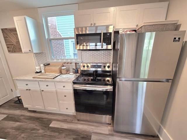 690 E Kossuth St, Columbus, OH 43206 - kitchen featuring stainless steel appliances, dark wood-style flooring, tasteful backsplash, and white cabinets