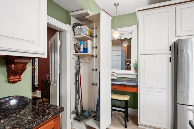 1042 Neil Ave, Columbus, OH 43201 - kitchen with freestanding refrigerator, white cabinets, dark stone counters, and hanging light fixtures