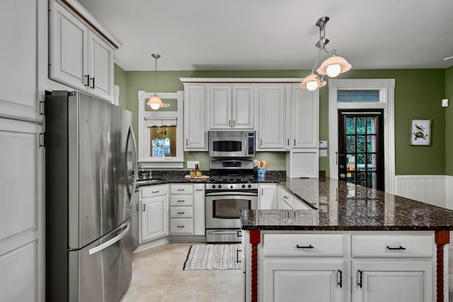 1042 Neil Ave, Columbus, OH 43201 - kitchen with appliances with stainless steel finishes, a peninsula, a sink, and decorative light fixtures