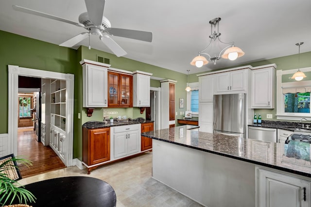 1042 Neil Ave, Columbus, OH 43201 - kitchen with stainless steel appliances, a sink, decorative light fixtures, and dark stone counters