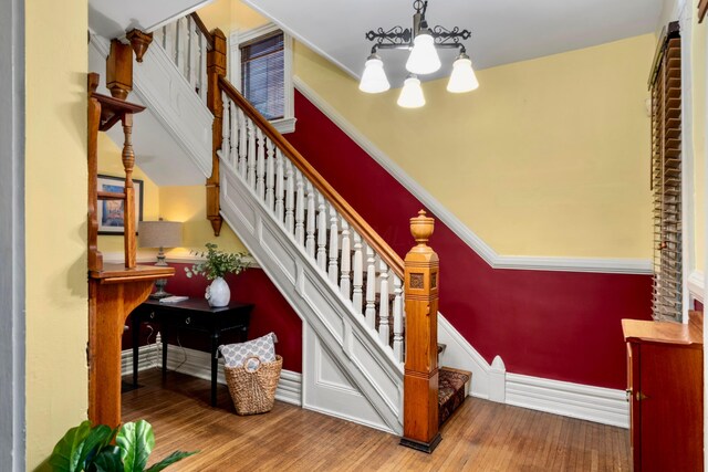 1042 Neil Ave, Columbus, OH 43201 - stairway featuring a chandelier, wood finished floors, and baseboards
