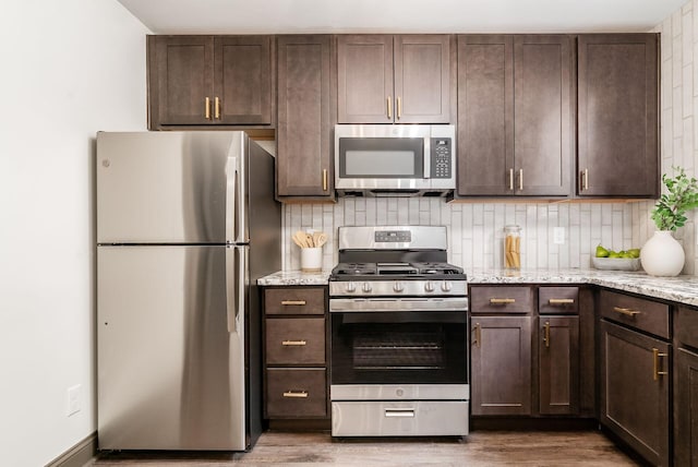 46 E Markison Ave, Columbus, OH 43207 - kitchen with appliances with stainless steel finishes, dark brown cabinets, wood finished floors, and backsplash