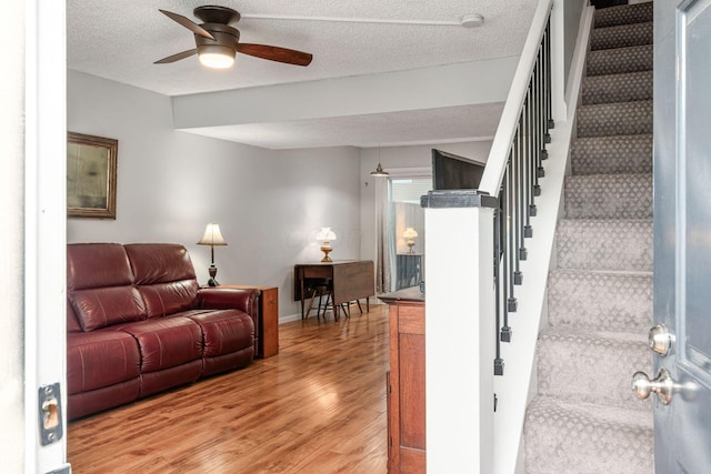 5120 Singleton Dr Unit 36D, Hilliard, OH 43026 - living area with light wood-style floors, stairs, a ceiling fan, a textured ceiling, and baseboards